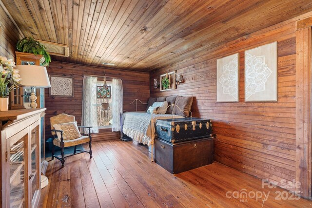 bedroom featuring wood walls, wood-type flooring, and wood ceiling