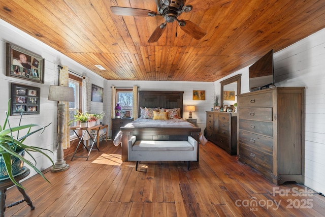 bedroom featuring wood-type flooring, ceiling fan, wood walls, and wood ceiling