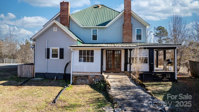 view of front of home with french doors and a front lawn