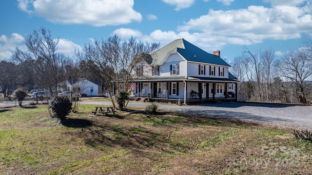 view of front of house with covered porch and a front lawn