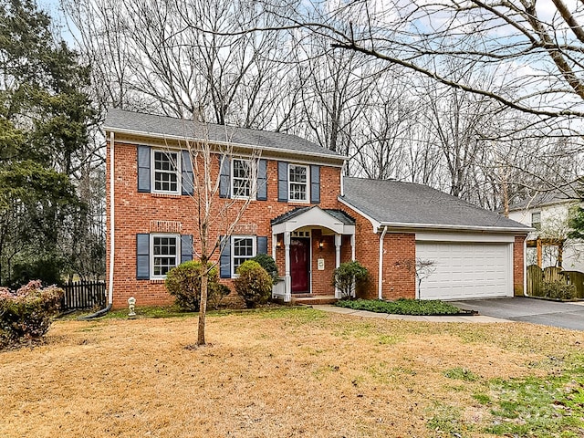 colonial inspired home with a garage and a front yard