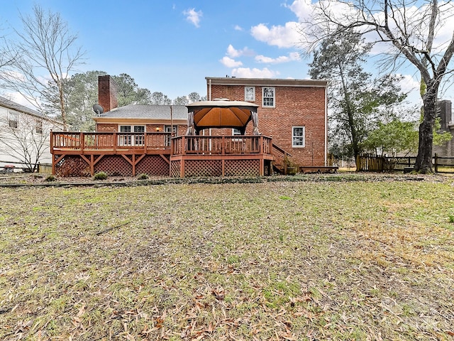 rear view of property featuring a gazebo, a yard, and a wooden deck