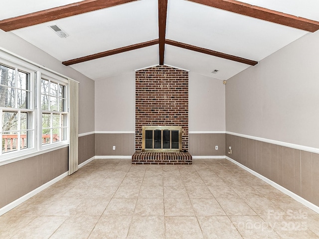 unfurnished living room featuring a fireplace, light tile patterned floors, and lofted ceiling with beams