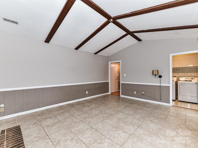 unfurnished living room with washing machine and dryer, tile patterned flooring, and lofted ceiling with beams