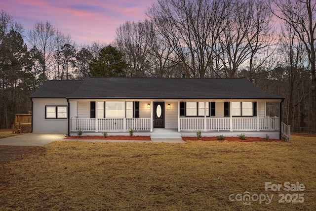 ranch-style house featuring a porch and a yard