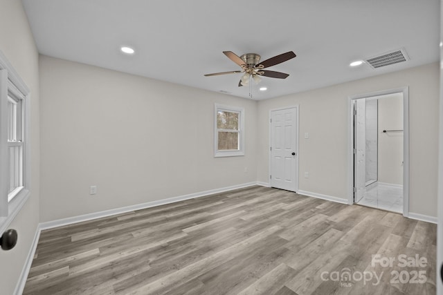 unfurnished bedroom with ceiling fan, light wood-type flooring, and ensuite bath