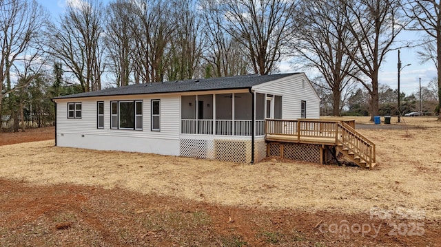 exterior space featuring a wooden deck and a sunroom