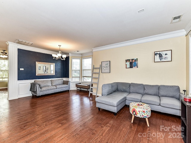 living room featuring hardwood / wood-style floors, a notable chandelier, and ornamental molding