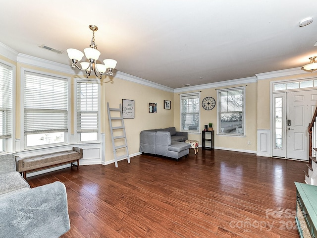 living room featuring ornamental molding, dark hardwood / wood-style floors, and an inviting chandelier