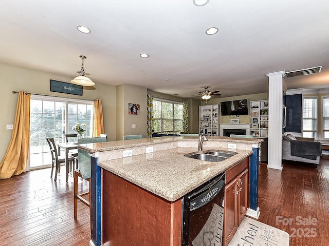 kitchen with ceiling fan, sink, black dishwasher, an island with sink, and decorative light fixtures