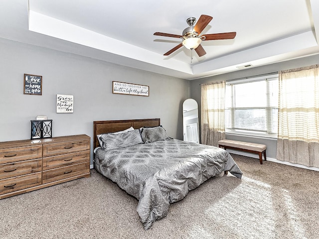 bedroom featuring carpet flooring, ceiling fan, and a raised ceiling