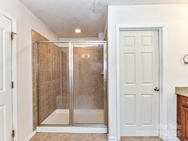 bathroom featuring tile patterned floors, vanity, and a shower with shower door