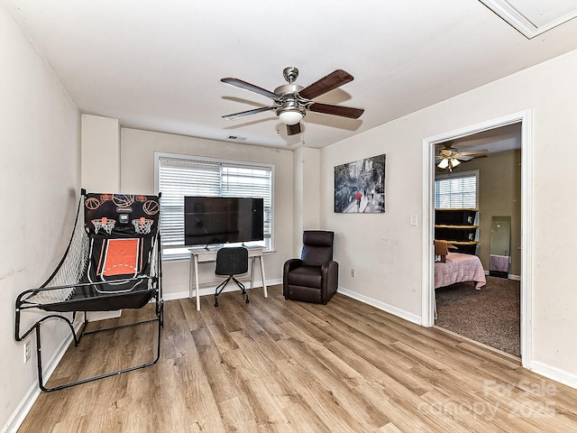 sitting room with a wealth of natural light, ceiling fan, and light wood-type flooring