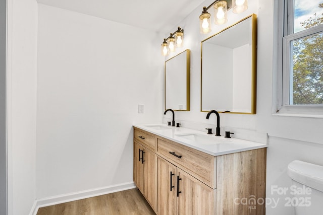 bathroom featuring wood-type flooring, vanity, and toilet