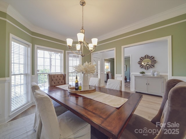 dining room featuring a chandelier, light hardwood / wood-style floors, and crown molding