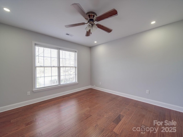 empty room with ceiling fan and dark wood-type flooring