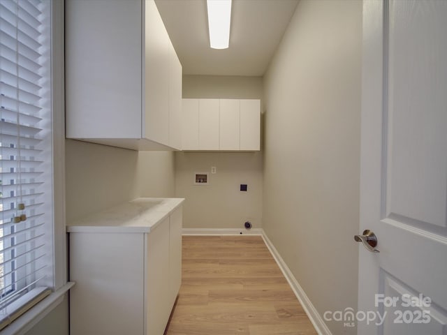 laundry area featuring cabinets, hookup for a washing machine, light hardwood / wood-style flooring, and a healthy amount of sunlight