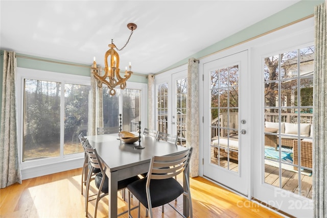 sunroom with an inviting chandelier and french doors