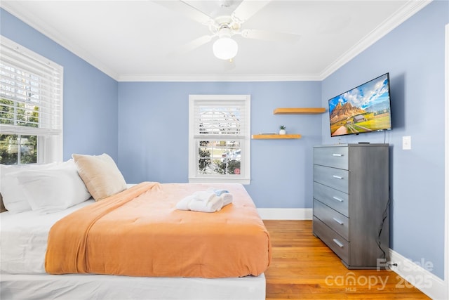 bedroom with crown molding, wood-type flooring, and ceiling fan