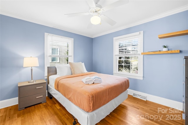 bedroom featuring hardwood / wood-style flooring, crown molding, and ceiling fan