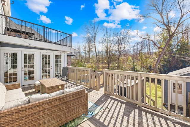 wooden terrace with an outdoor living space and french doors