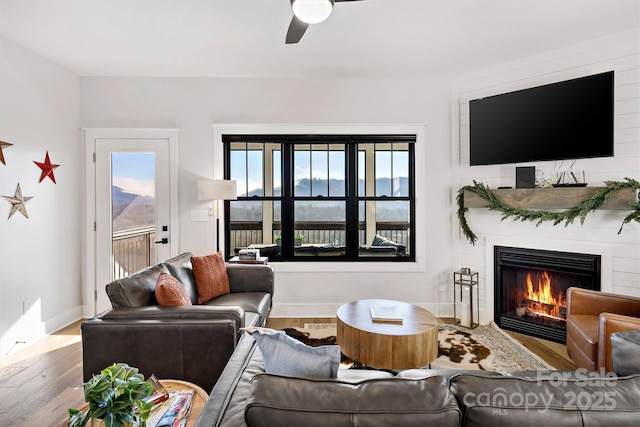 living room featuring wood-type flooring and ceiling fan