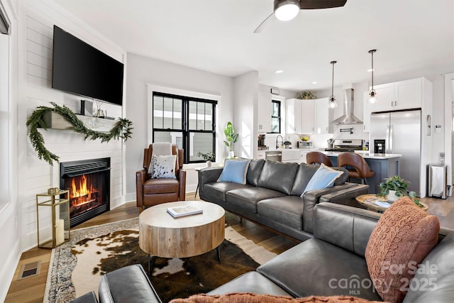 living room featuring hardwood / wood-style flooring and ceiling fan