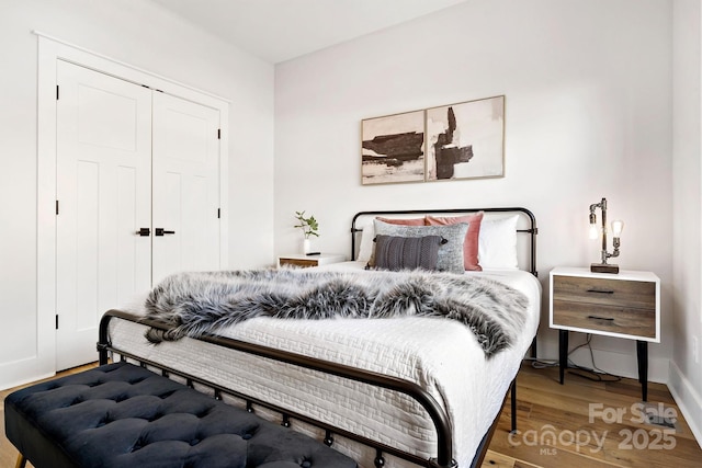 bedroom with a closet and hardwood / wood-style flooring