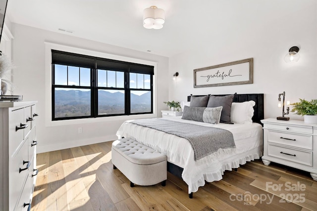 bedroom featuring a mountain view and hardwood / wood-style flooring