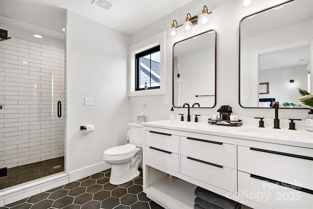 bathroom with tile patterned floors, vanity, an enclosed shower, and toilet