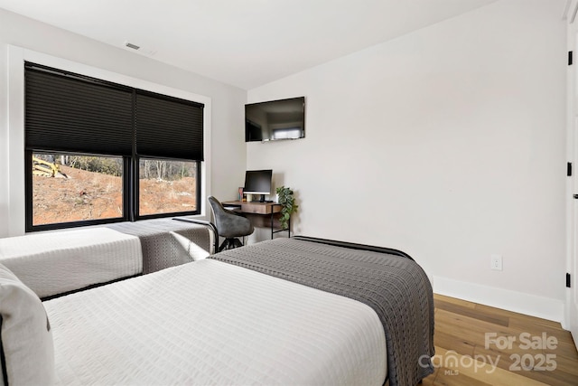 bedroom featuring vaulted ceiling and hardwood / wood-style flooring