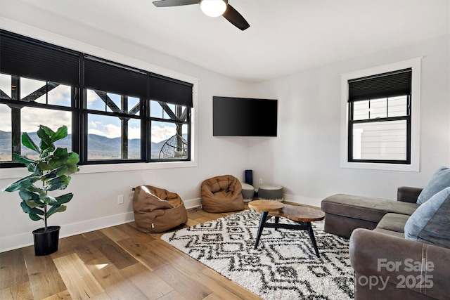 living room with hardwood / wood-style flooring, a wealth of natural light, and ceiling fan