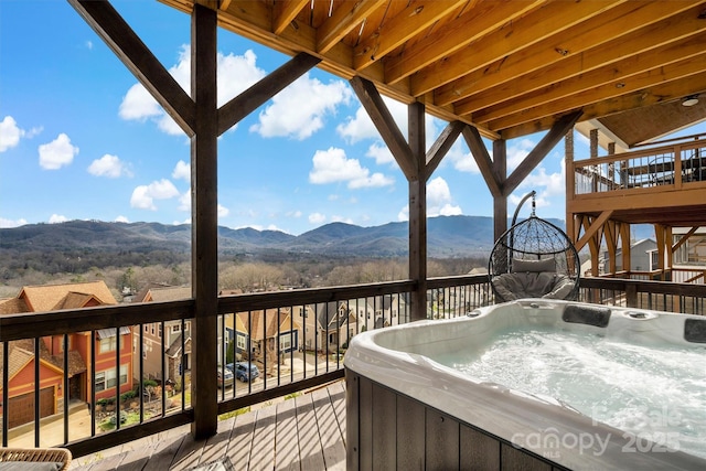 wooden terrace featuring a mountain view and a hot tub