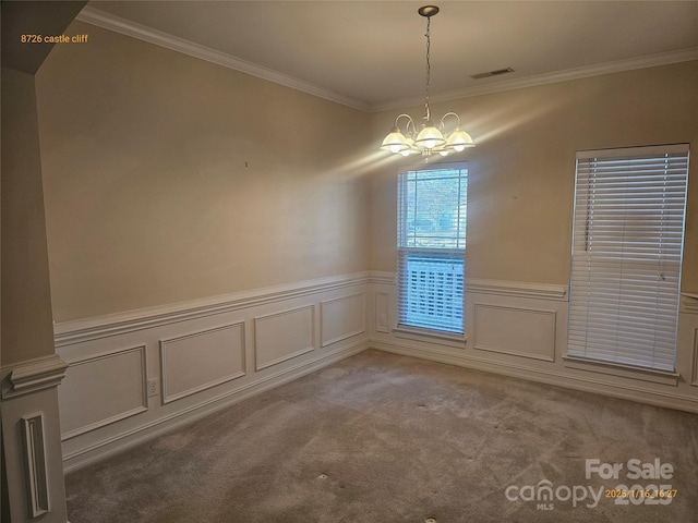 carpeted empty room featuring an inviting chandelier and ornamental molding