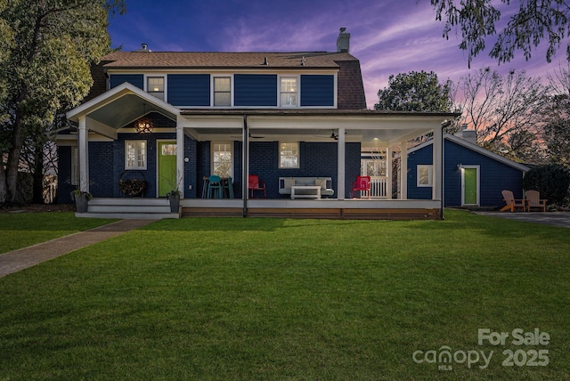 view of front facade featuring a lawn and ceiling fan