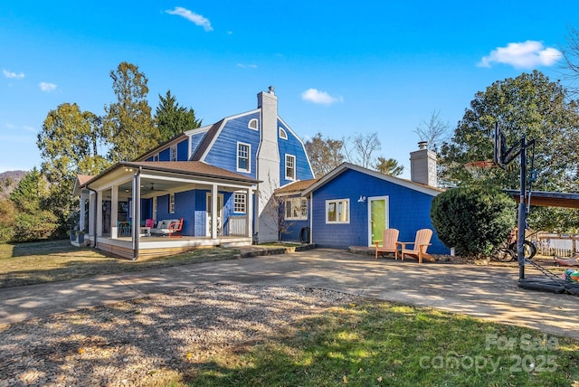 rear view of house featuring covered porch and ceiling fan