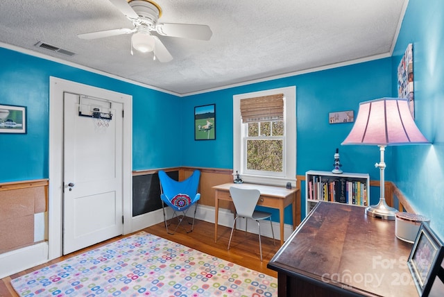 home office featuring ceiling fan, crown molding, a textured ceiling, and hardwood / wood-style flooring