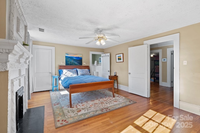 bedroom with ceiling fan, hardwood / wood-style floors, and a textured ceiling