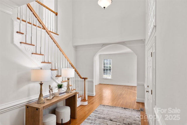 foyer with ornamental molding and light wood-type flooring