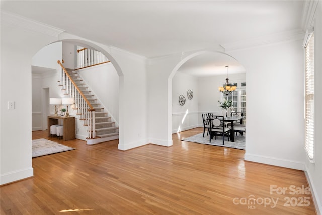 interior space with crown molding, wood-type flooring, and a notable chandelier