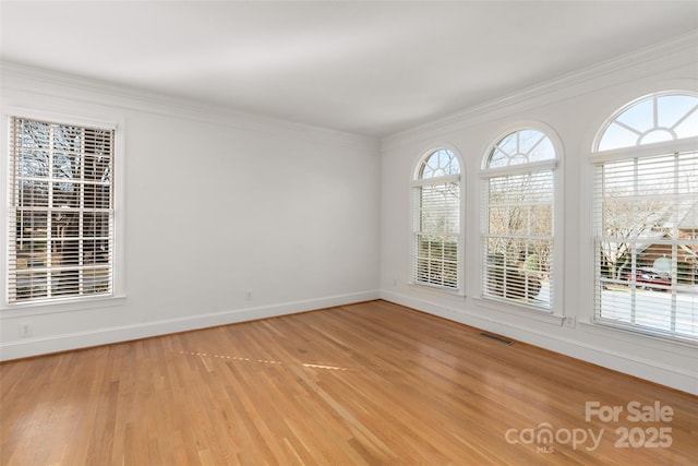 empty room featuring crown molding and light hardwood / wood-style floors