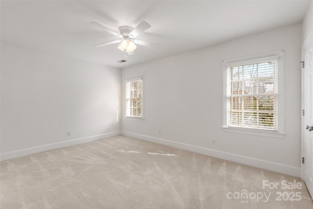 spare room with ceiling fan and light carpet