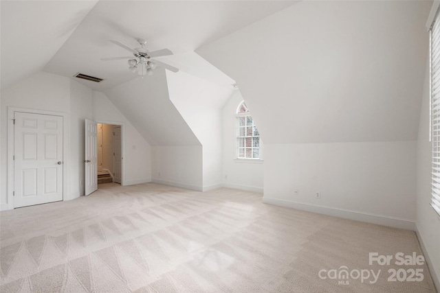 bonus room with vaulted ceiling, light colored carpet, and ceiling fan