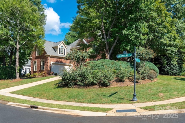 view of property hidden behind natural elements with a garage and a front yard