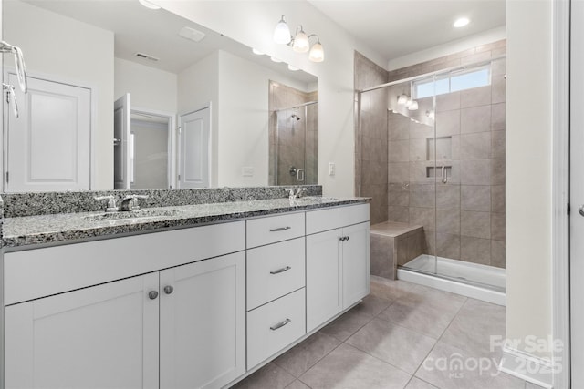 bathroom with tile patterned flooring, vanity, and walk in shower