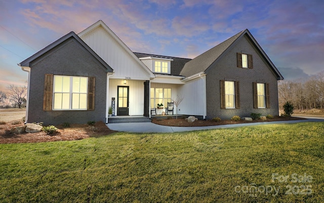 modern farmhouse style home with a lawn and a porch