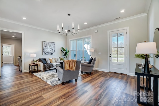 living room with crown molding, dark wood-type flooring, and a chandelier