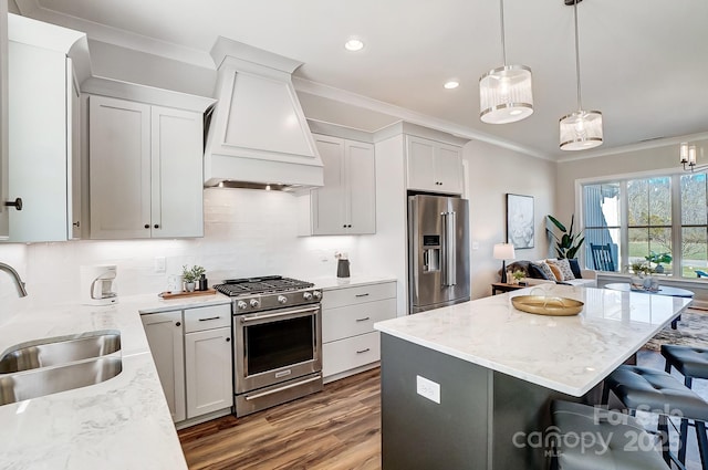 kitchen featuring sink, custom exhaust hood, crown molding, hanging light fixtures, and high quality appliances