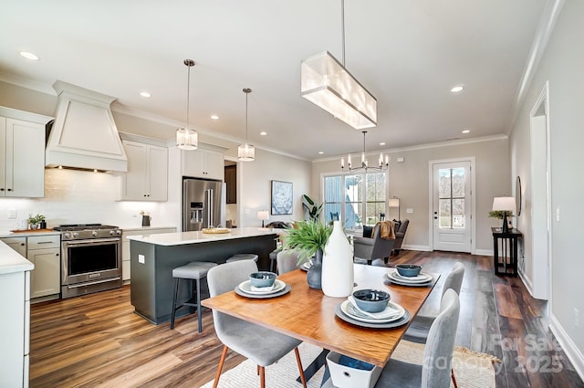 dining room featuring hardwood / wood-style floors, ornamental molding, and a chandelier