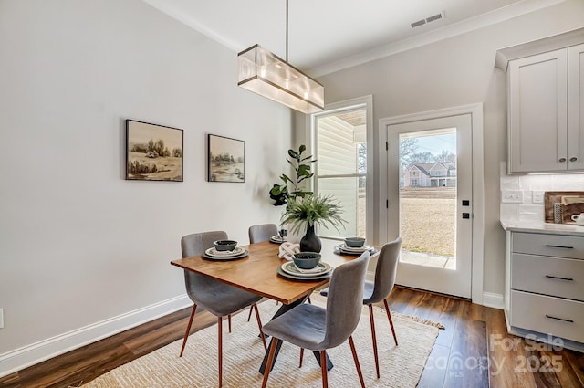 dining space featuring ornamental molding, plenty of natural light, and dark hardwood / wood-style floors